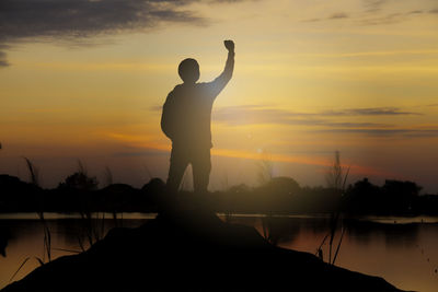 
silhouette of a happy man raised hands up as a successful, victory and achieve a business goal.