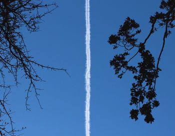 Low angle view of contrail at blue sky