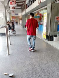 Rear view of man walking on street in city
