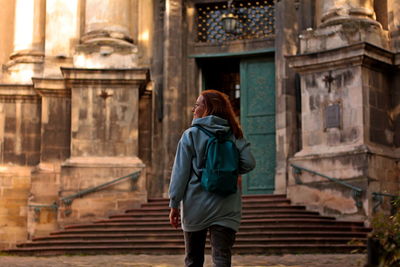 Young woman traveling with backpack, old city