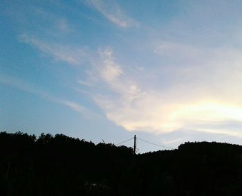 Low angle view of silhouette trees against sky