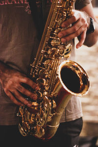 Midsection of man playing saxophone