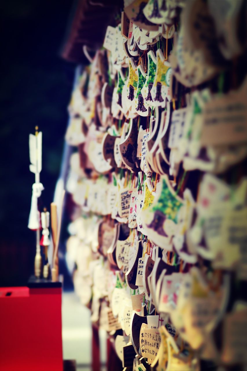 selective focus, focus on foreground, indoors, close-up, religion, metal, spirituality, hanging, art and craft, place of worship, tradition, no people, cultures, low angle view, metallic, part of, temple - building, old, art, in a row