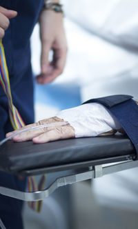 Cropped hand of patient with medical equipment in hospital