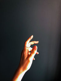 Cropped image of hand against black background