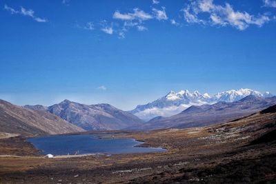 Scenic view of lake and mountains against blue sky