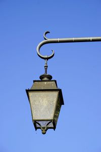 Low angle view of electric lamp against clear blue sky