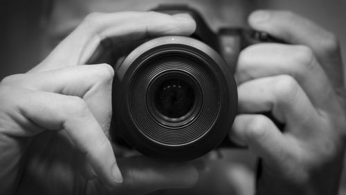 Close-up of man photographing by using camera