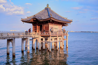 View of pier on sea against cloudy sky
