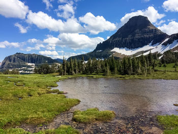 Scenic view of lake by mountains against sky