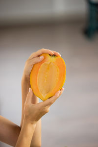 Close-up of woman holding orange fruit