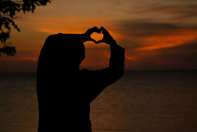 Silhouette man at beach during sunset