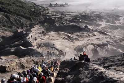 People on cliff against mountains