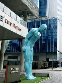 Statue against modern building in city