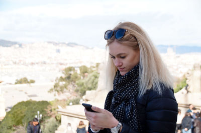 Young woman using mobile phone while standing outdoors