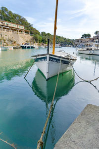 Sailboats moored on sea against sky