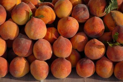 Delicious, fresh peaches piled up on a market stall