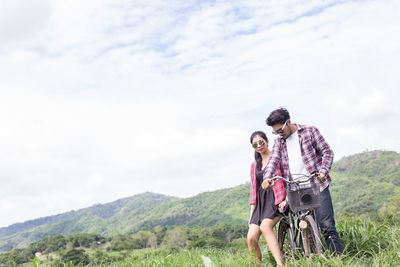 Young couple on mountain against sky