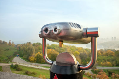 Close-up of coin-operated binoculars against sky