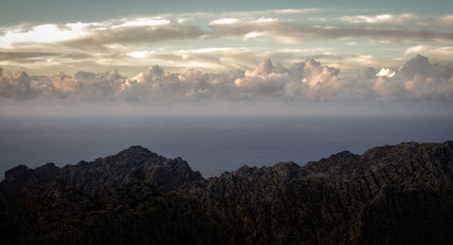 Scenic view of sea and mountains against sky