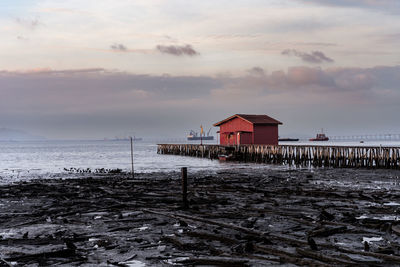 Sunrise view of wooden bridge and red house background at clan tan jetty, penang, malaysia.