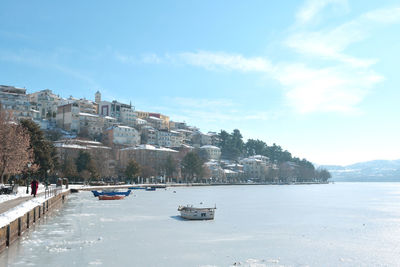 Pedestrian alley on the banks of frozen lake orestiada in kastoria, greece on a sunny day