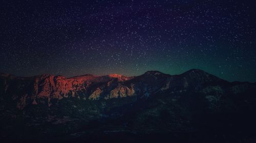 Scenic view of mountains against sky at night