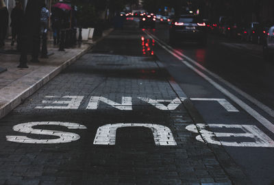 Road sign on street in city at night