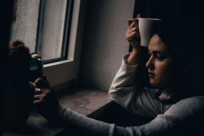 Young woman drinking coffee at home