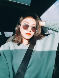 Portrait of beautiful young woman sitting in car