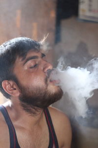 Close-up of man smoking at home