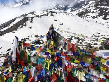 Multi colored flags on snowcapped mountain against sky