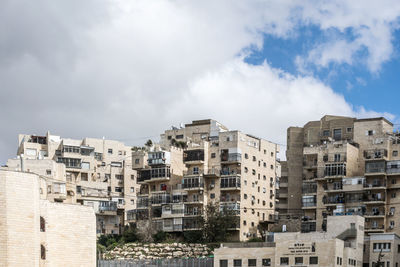 Low angle view of buildings against cloudy sky