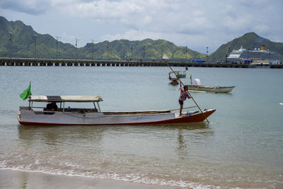 Fishing boat in sea against sky