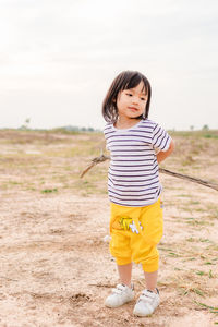 Portrait of smiling girl standing on field