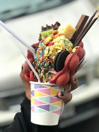 Close-up of hand holding dessert in cup