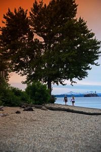 People walking by sea against sky