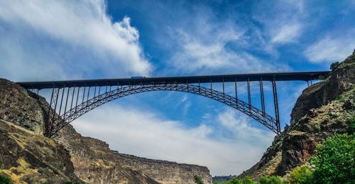 Low angle view of bridge against cloudy sky