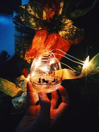 Close-up of hand holding illuminated light bulb