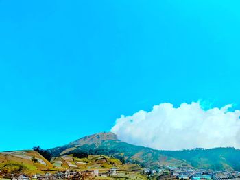 Scenic view of mountains against blue sky