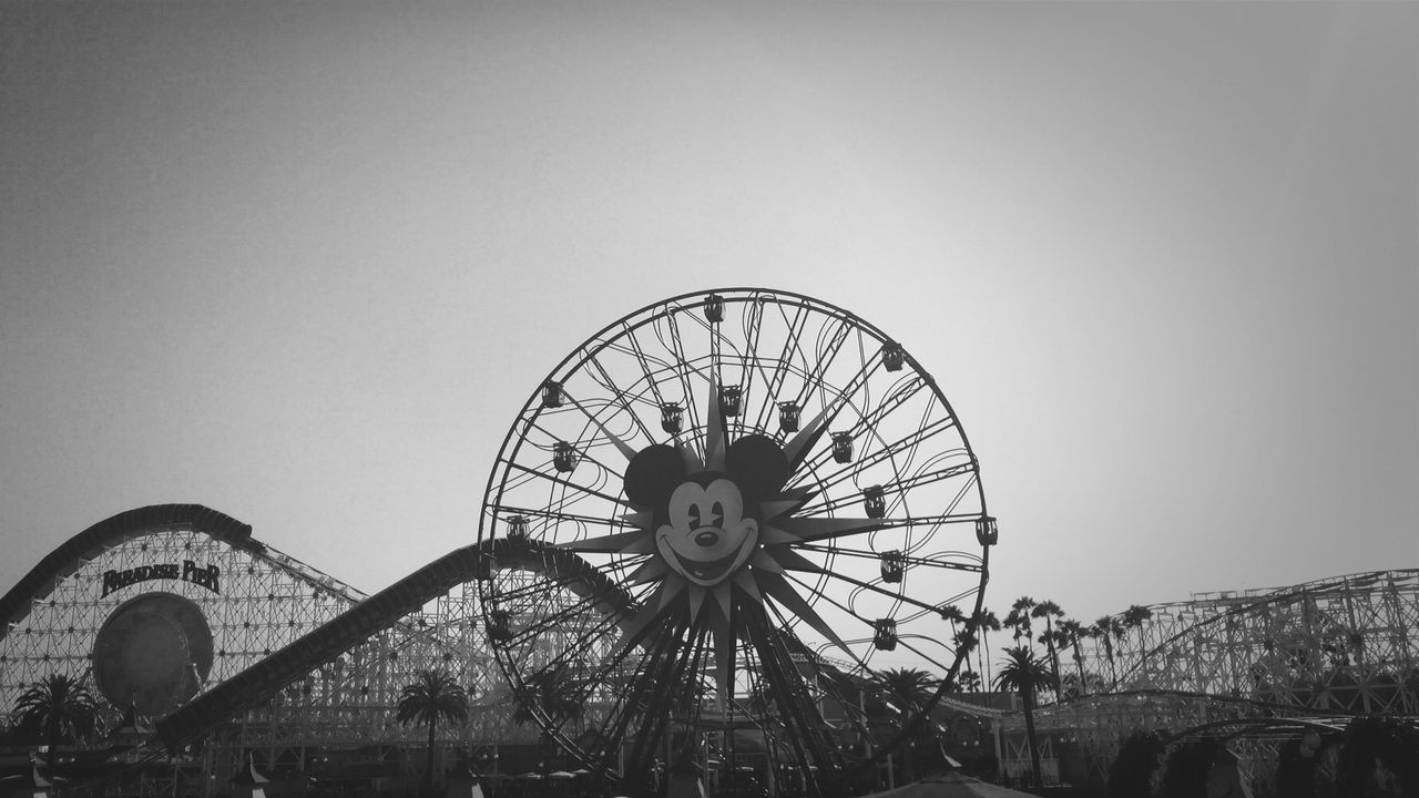 ferris wheel, clear sky, built structure, architecture, copy space, amusement park ride, amusement park, circle, arts culture and entertainment, low angle view, building exterior, sky, day, outdoors, travel, wheel, geometric shape, travel destinations, no people, time