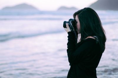 Rear view of woman photographing through camera