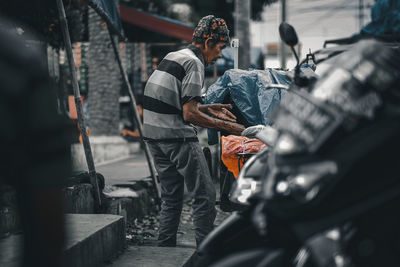 Rear view of man working at garage