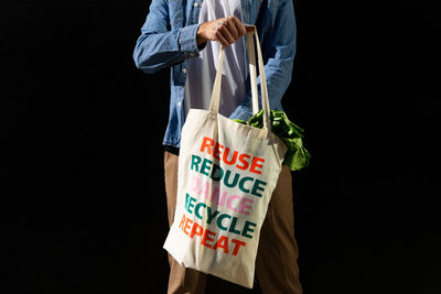 Midsection of man with text against black background