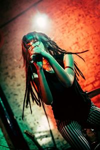 Low angle view of woman on illuminated wall