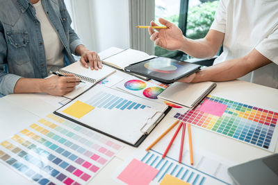 Midsection of business colleagues working on table