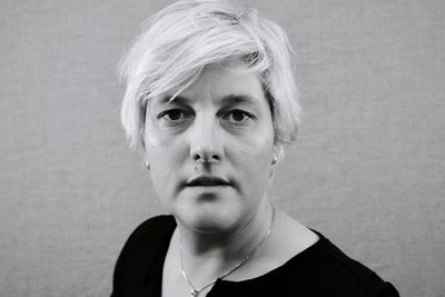 Portrait of woman with short hair against wall