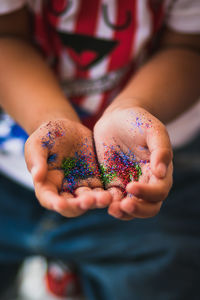 Midsection of boy holding confetti