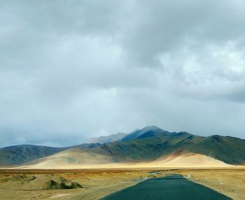 Road by landscape against sky