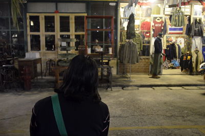 Rear view of woman walking on street in city